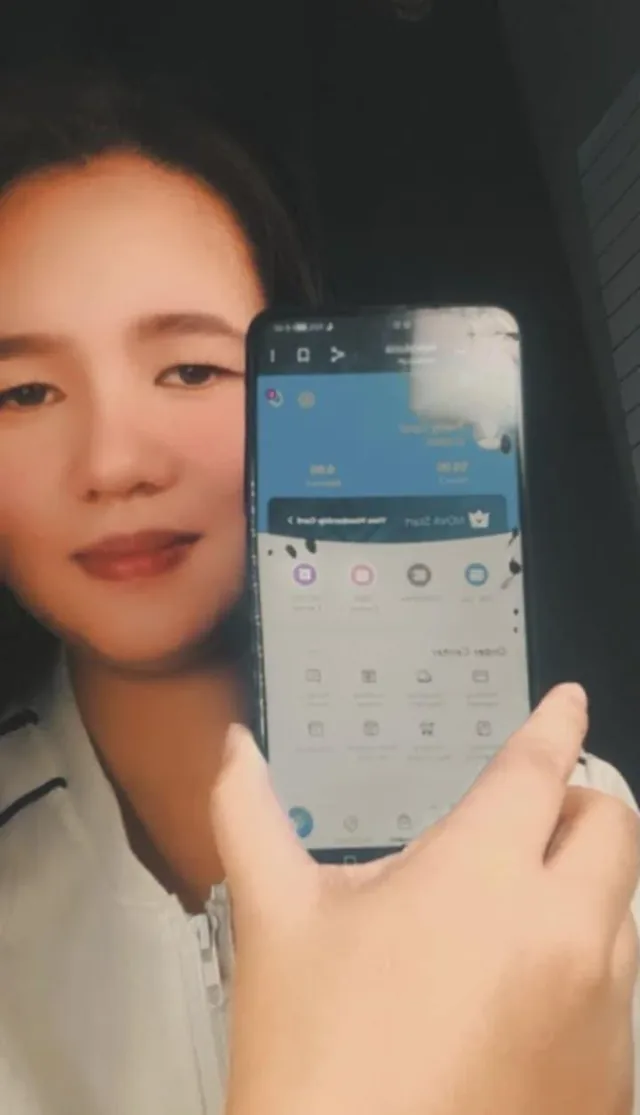 A user in a car holding up a phone showing the Novaluxia app